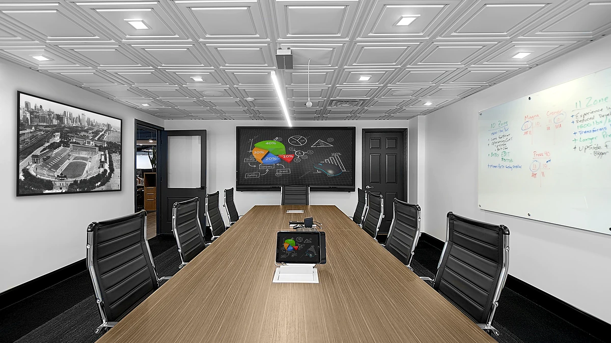 Office Interior Modern conference room with a long wooden table, black leather chairs, whiteboard, wall charts, and a chalkboard display.