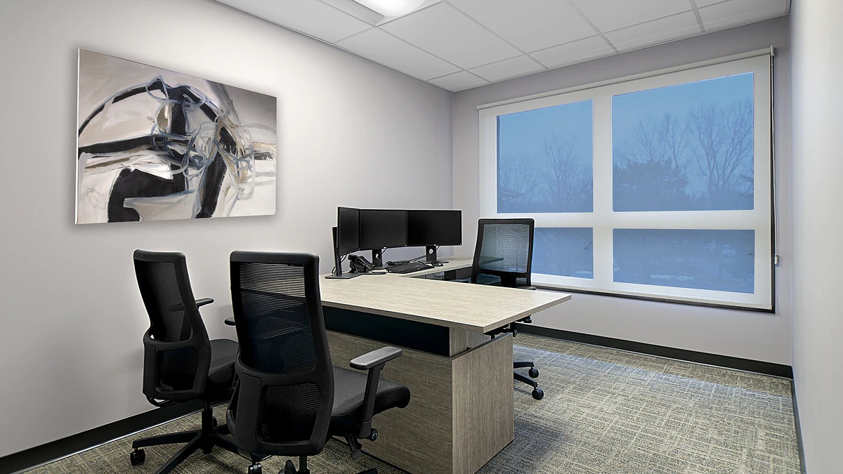 Office Interior Modern office with a light wood desk and dual monitors, three black mesh chairs, abstract wall art, and a large window.